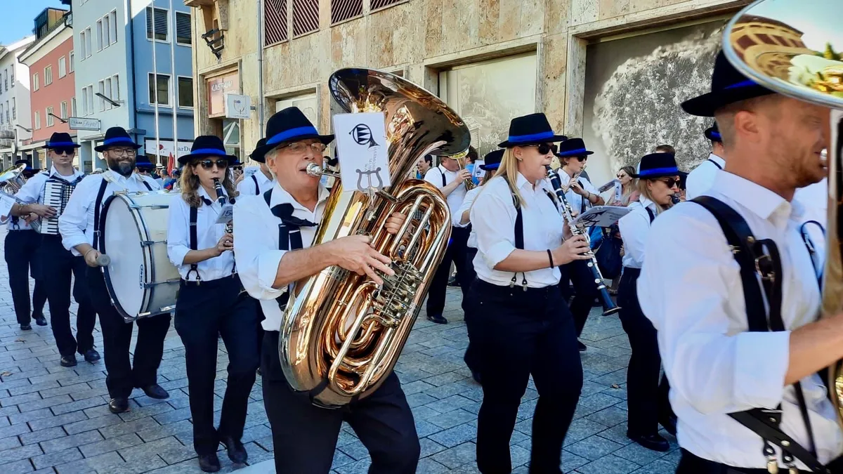 Eine Musikgesellschaft marschiert musizierend durch einen Ort.